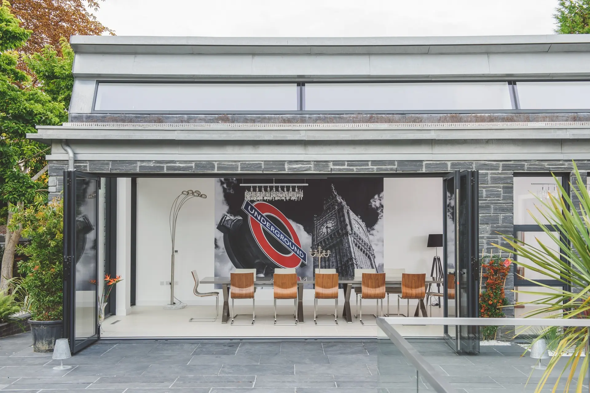 Indoor-outdoor dining space with open glazed doors