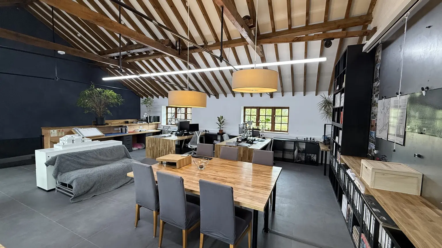 Open-plan architectural studio with oak worktables